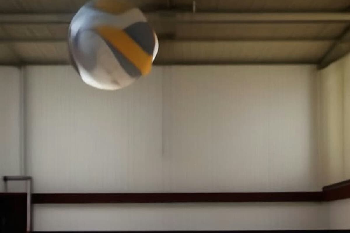Karaman'da düzenlenen voleybol kursu için hazırlanmış kapalı spor salonunda voleybol filesi, top ve antrenman ekipmanları.